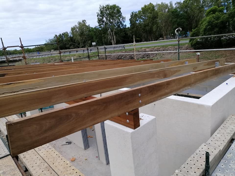 A Wooden Deck Is Being Built on Top of A White Wall — Semrau Constructions In Bentley Park, QLD