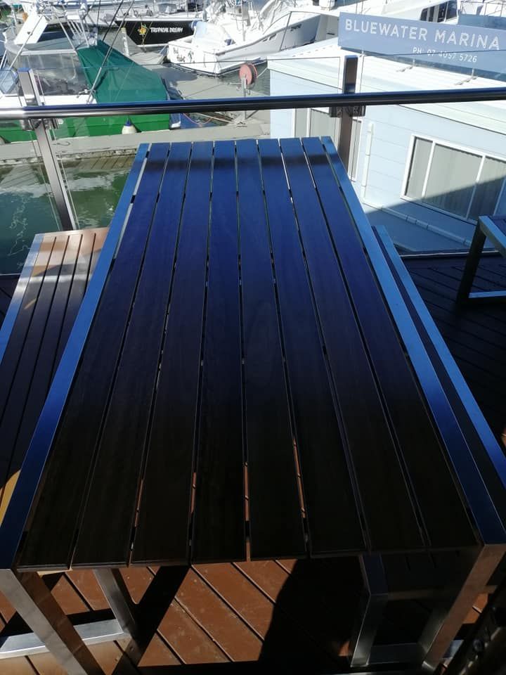 A Wooden Table on A Balcony Overlooking a Marina — Semrau Constructions In Bentley Park, QLD