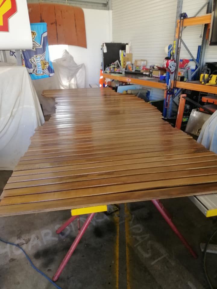 A Wooden Table in A Garage with A Shell Sign in The Background — Semrau Constructions In Bentley Park, QLD
