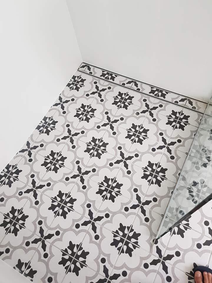 A Person Is Standing on A Tiled Floor with A Black and White Pattern — Semrau Constructions In Bentley Park, QLD