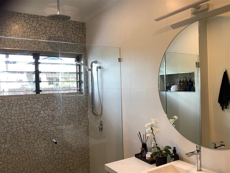 A Bathroom with A Sink, Shower, and Round Mirror — Semrau Constructions In Bentley Park, QLD
