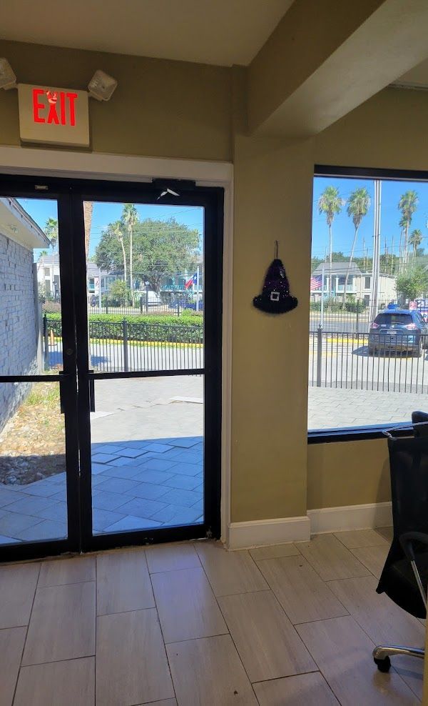 A red exit sign hangs above a glass door
