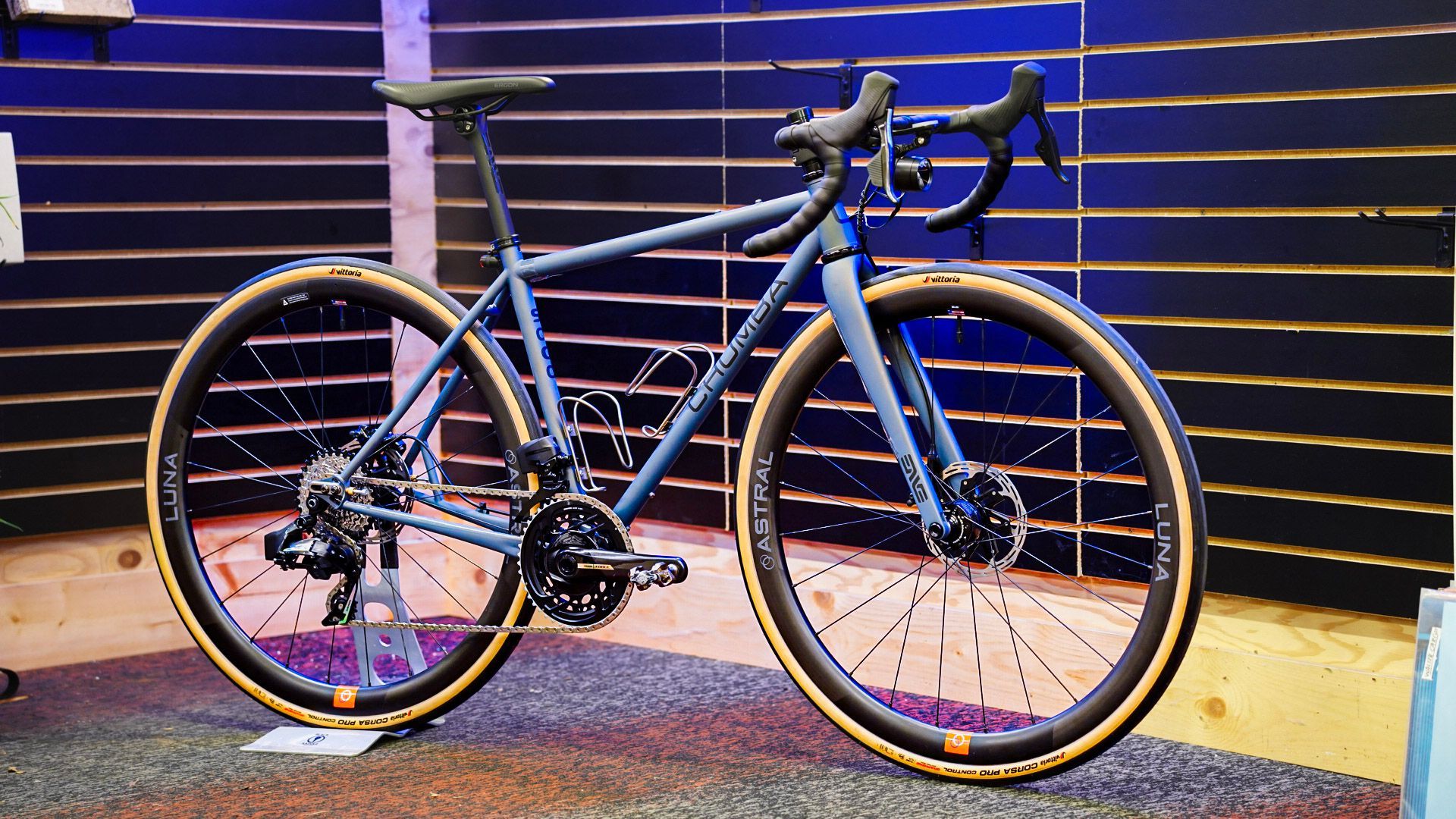 A blue bicycle is parked in front of a wall.