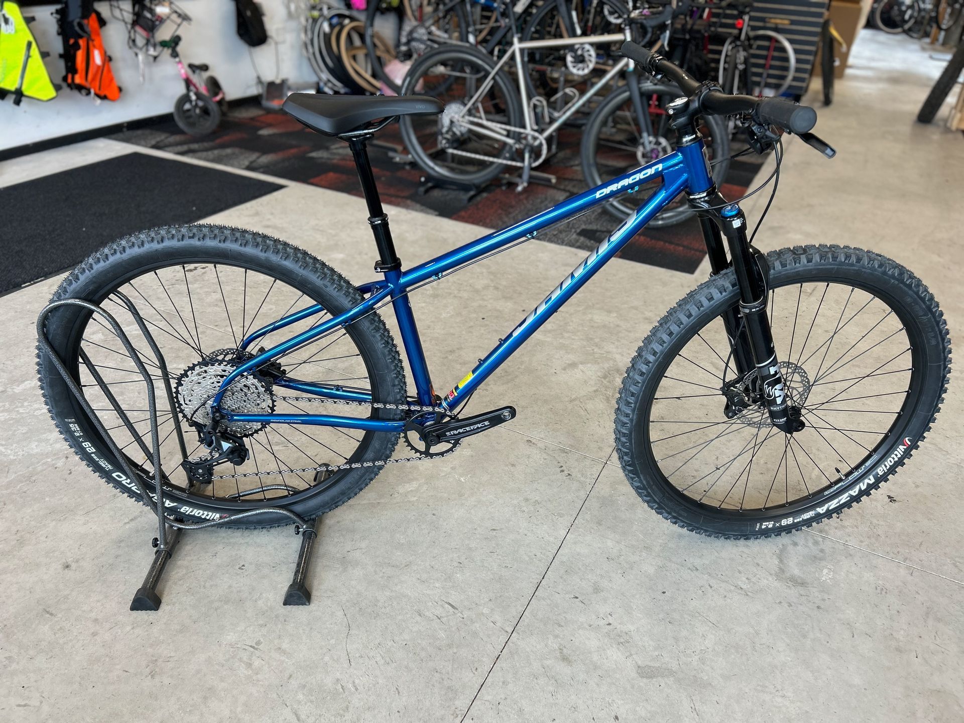 A blue bicycle is sitting on a stand in a store.