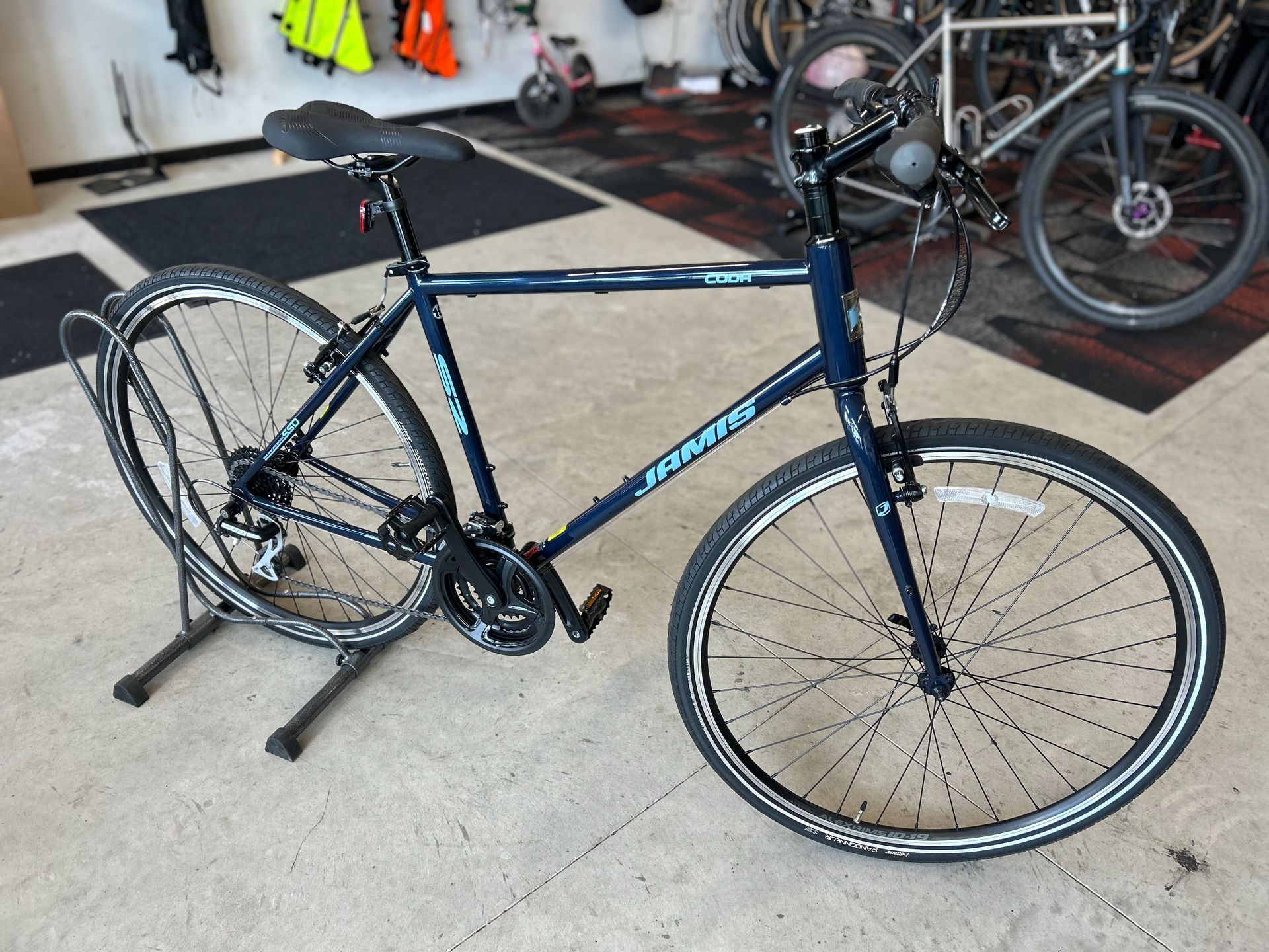 A blue bicycle is parked on a stand in a store