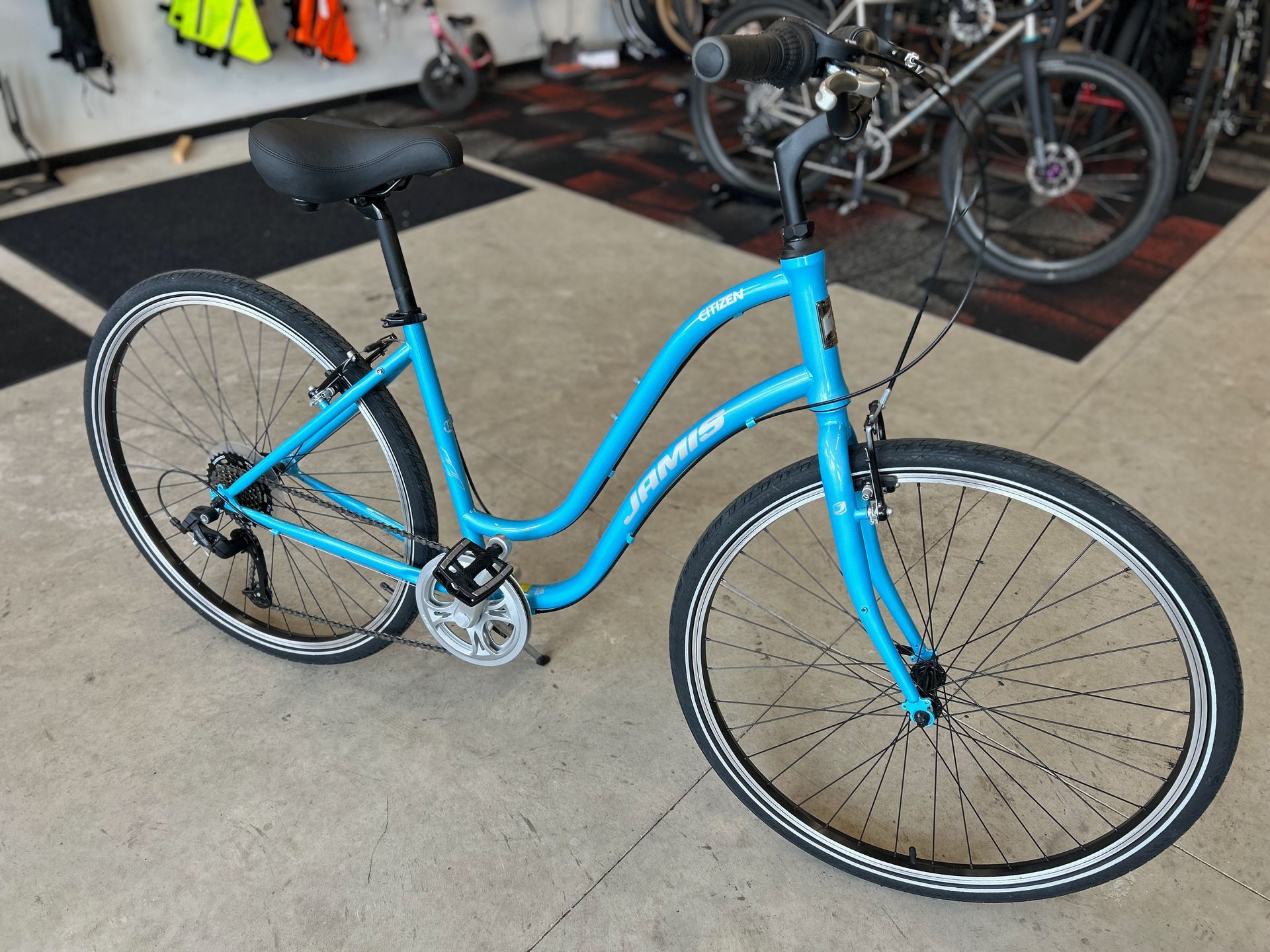 A blue bicycle is sitting on the floor in a store