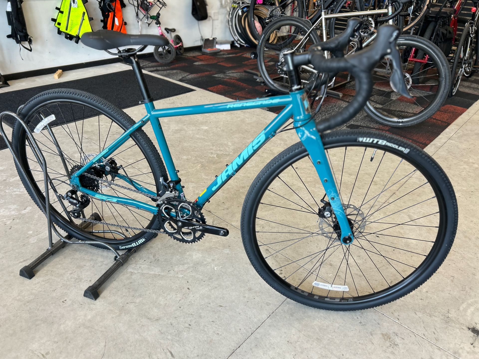 A blue bicycle is sitting on a stand in a store.