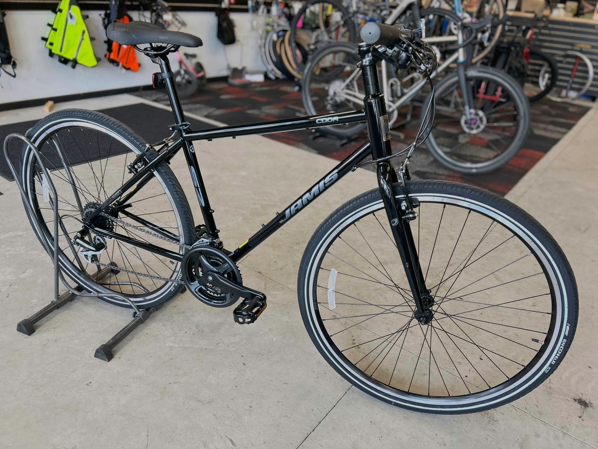 A black bicycle is parked on a stand in a store