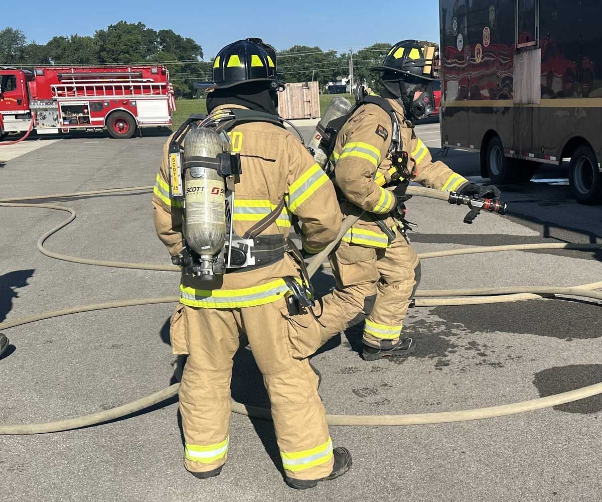 Two Tri-Township firemen in full gear during hose training