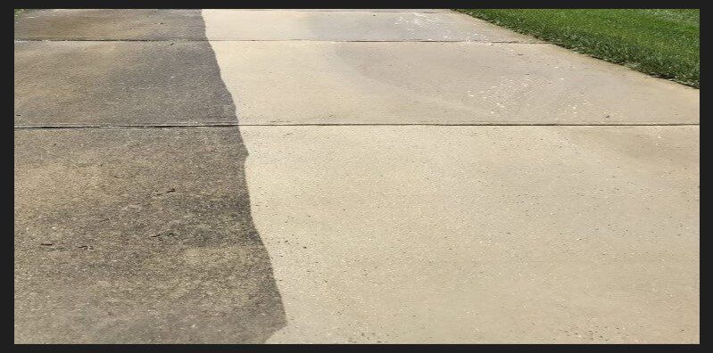 Half of a concrete walkway, cleaned with a power washer. The other half is dirty.