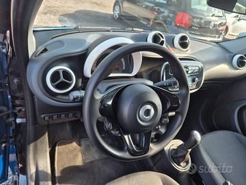 Vista interna del cruscotto di un'auto Suzuki con volante, console centrale e sedili. Sono visibili dettagli neri e argento.