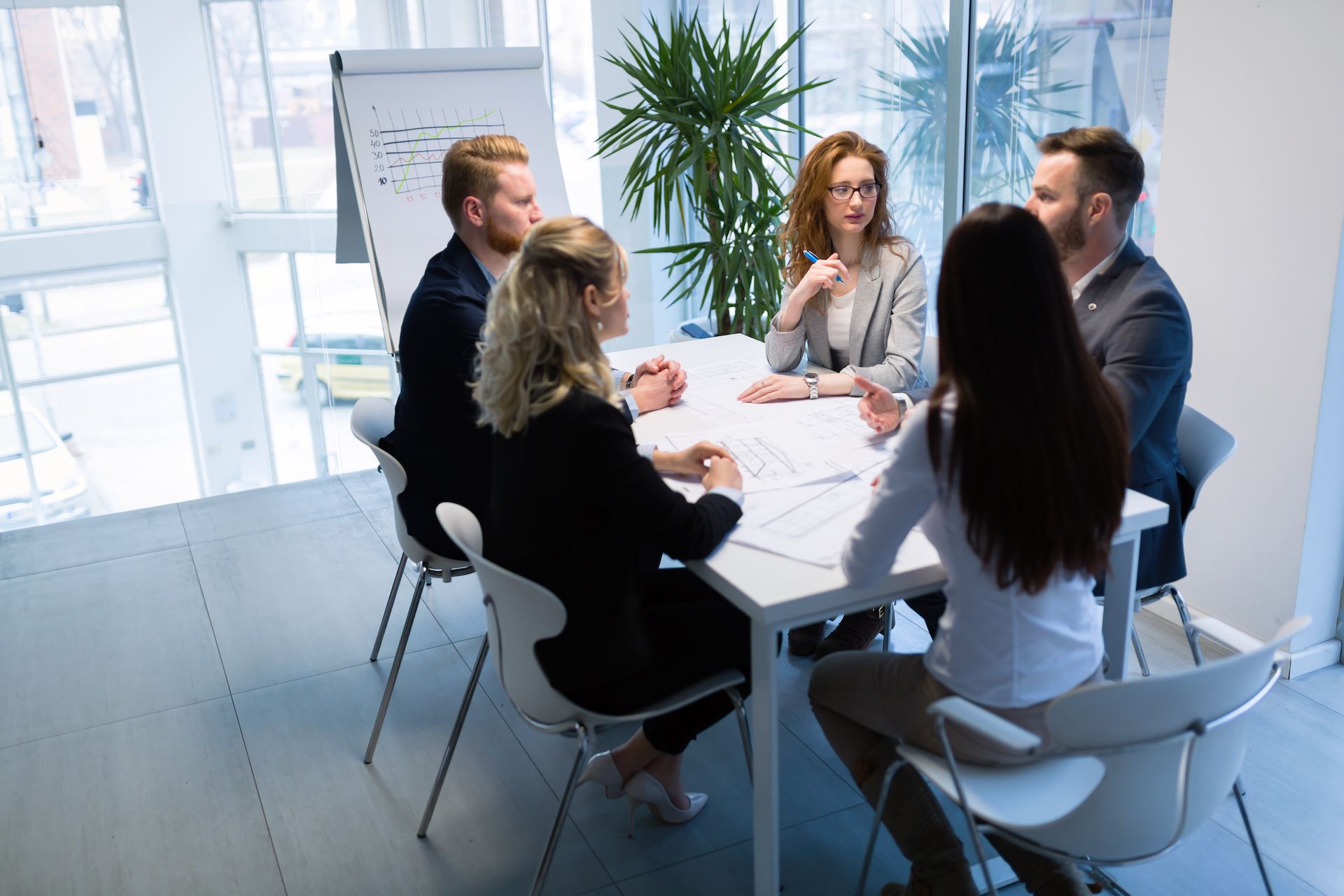 A group of people are sitting around a table having a meeting.