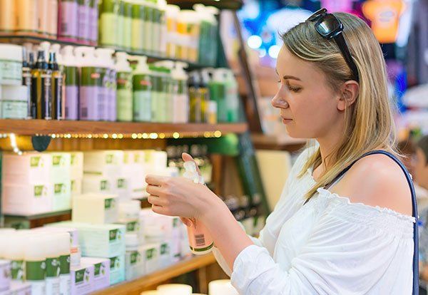 Young woman choosing cosmetic cream in beauty shop Young woman choosing cosmetic cream in beauty shop