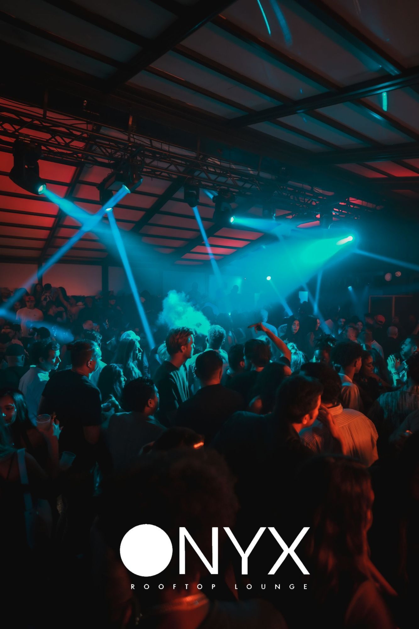 Party at Onyx Rooftop Slumos, people dancing under blue and red lights.