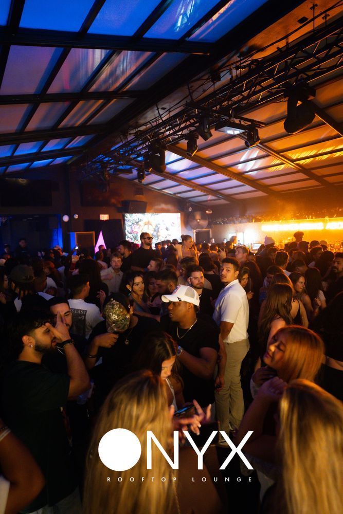 Nightclub interior packed with people; blue and orange lighting, 