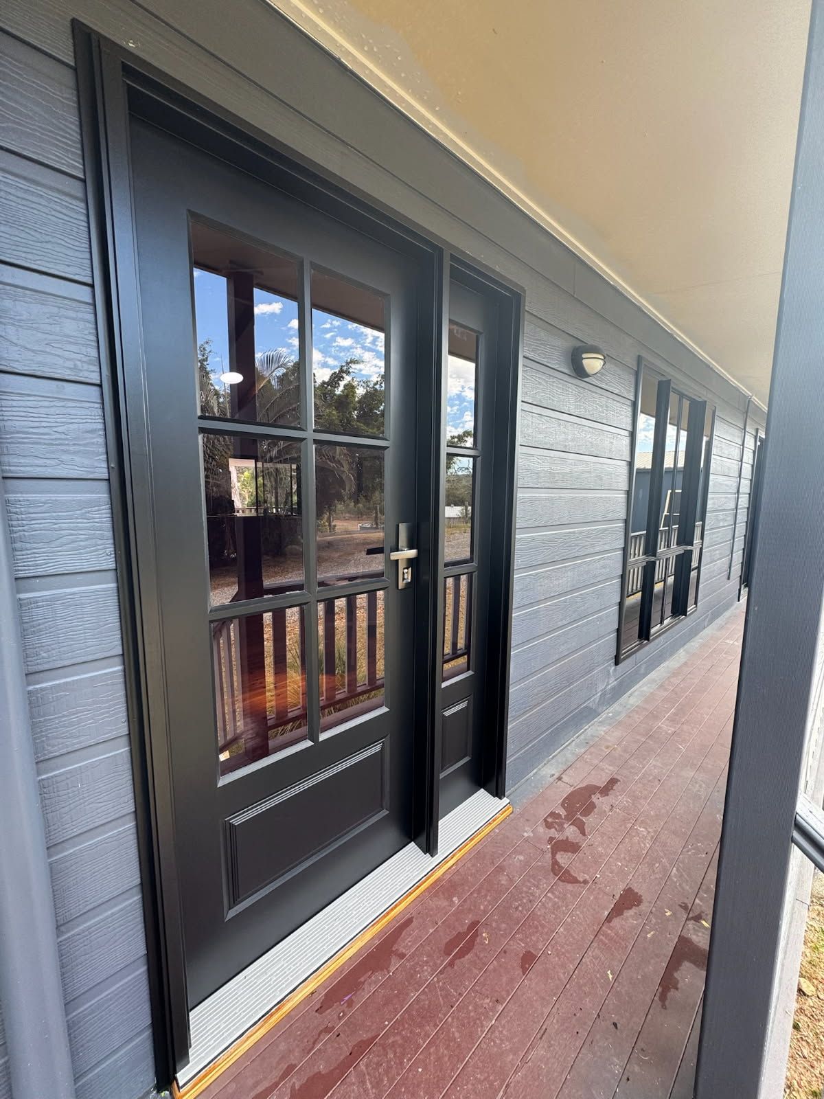A Black-framed Glass Door With Muntins on a Porch — Priority Painters in Gladstone Central, QLD