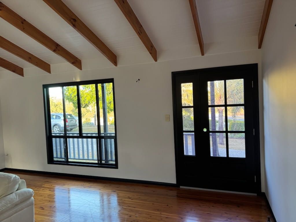 A Bright Living Room With Dark Exposed Ceiling Beams — Priority Painters in Gladstone Central, QLD
