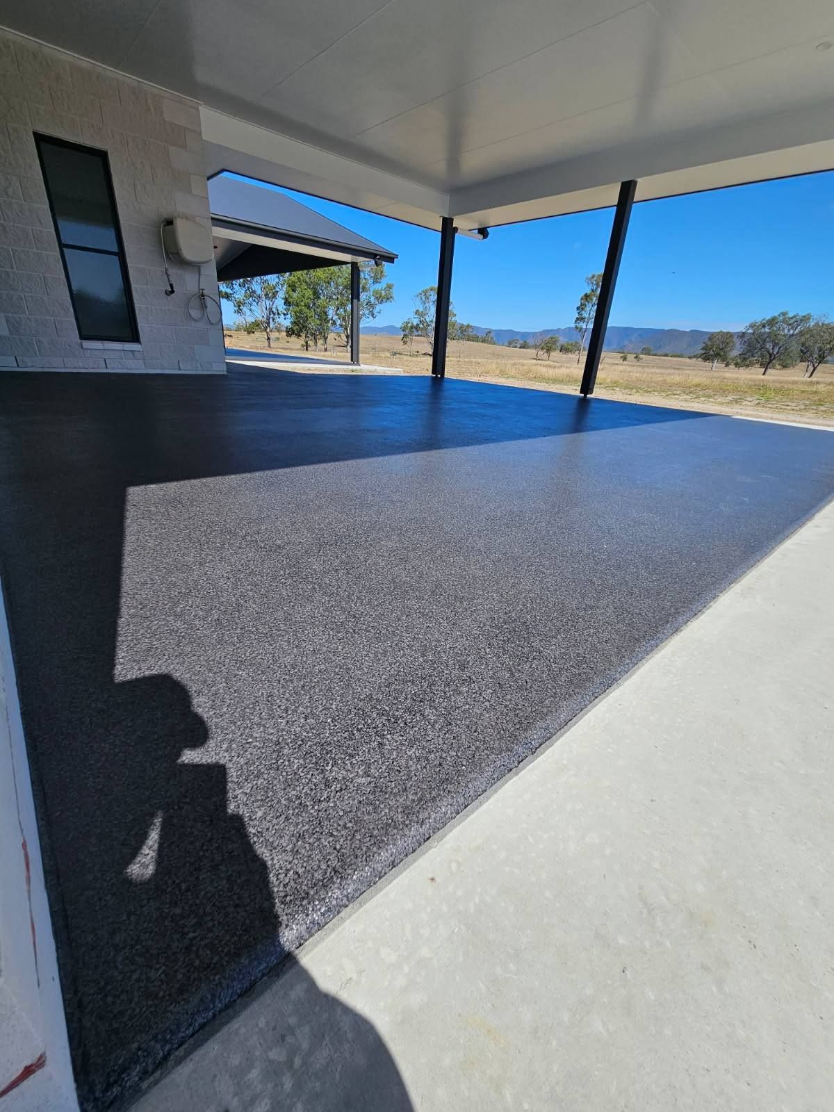 A Partially Finished Outdoor Concrete Patio Floor Featuring a Dark — Priority Painters in Gladstone Central, QLD