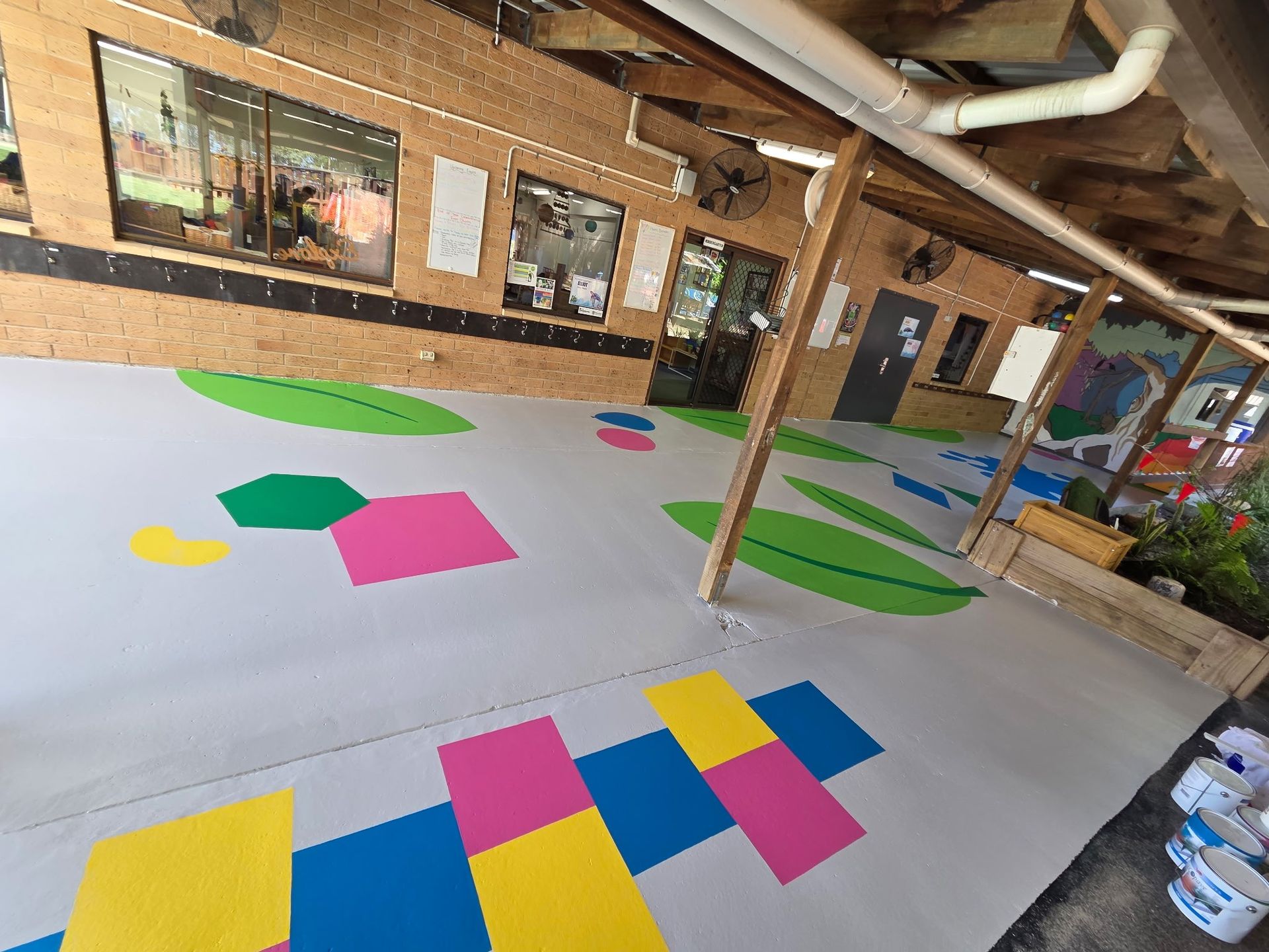 A Covered Patio Floor With Colorful, and Leaf-shaped Painted — Priority Painters in Gladstone Central, QLD