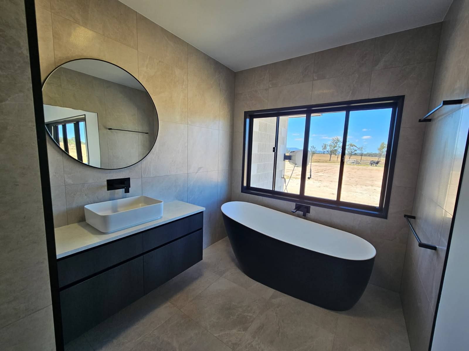 Modern Bathroom With a Black Floating Vanity, and Vessel Sink — Priority Painters in Gladstone Central, QLD