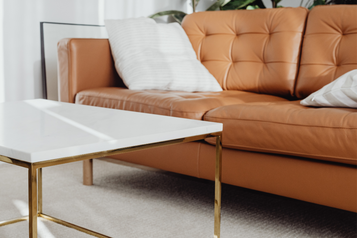 Moderne Küche mit grauer Steinwand, Holzakzenten, Kochinsel mit zwei Hockern und Türöffnung.