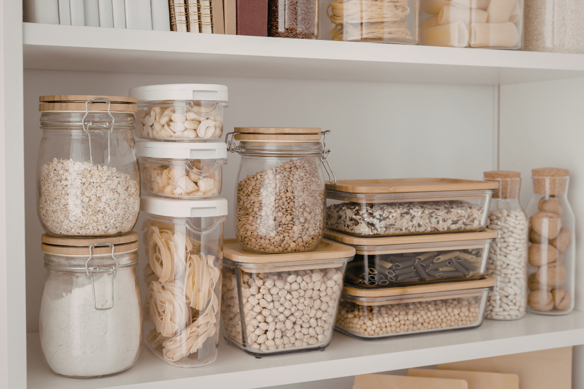 Hände ordnen gefaltete Socken in einem Schubladen-Organizer mit Fächern; verschiedene Farben sichtbar.