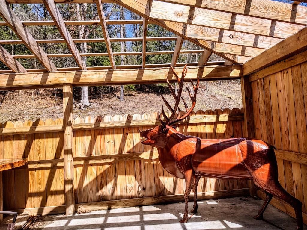 a statue of a deer in a wooden structure