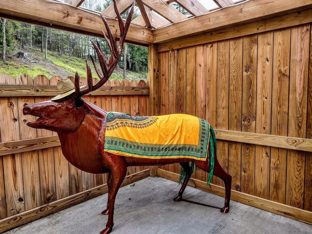 a statue of a deer wearing a hat and a yellow blanket