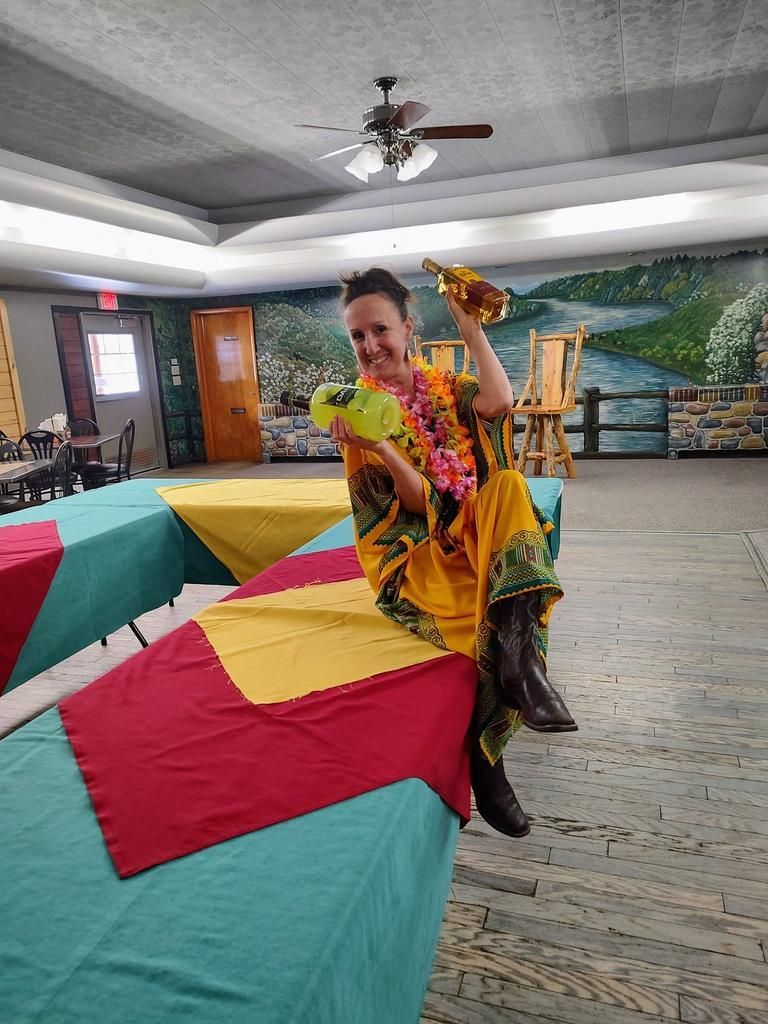 a woman sitting on a table holding a bottle of wine