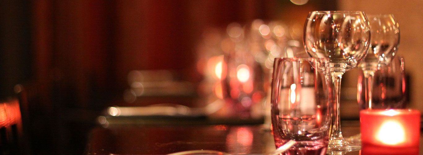 a table with wine glasses and candles on it