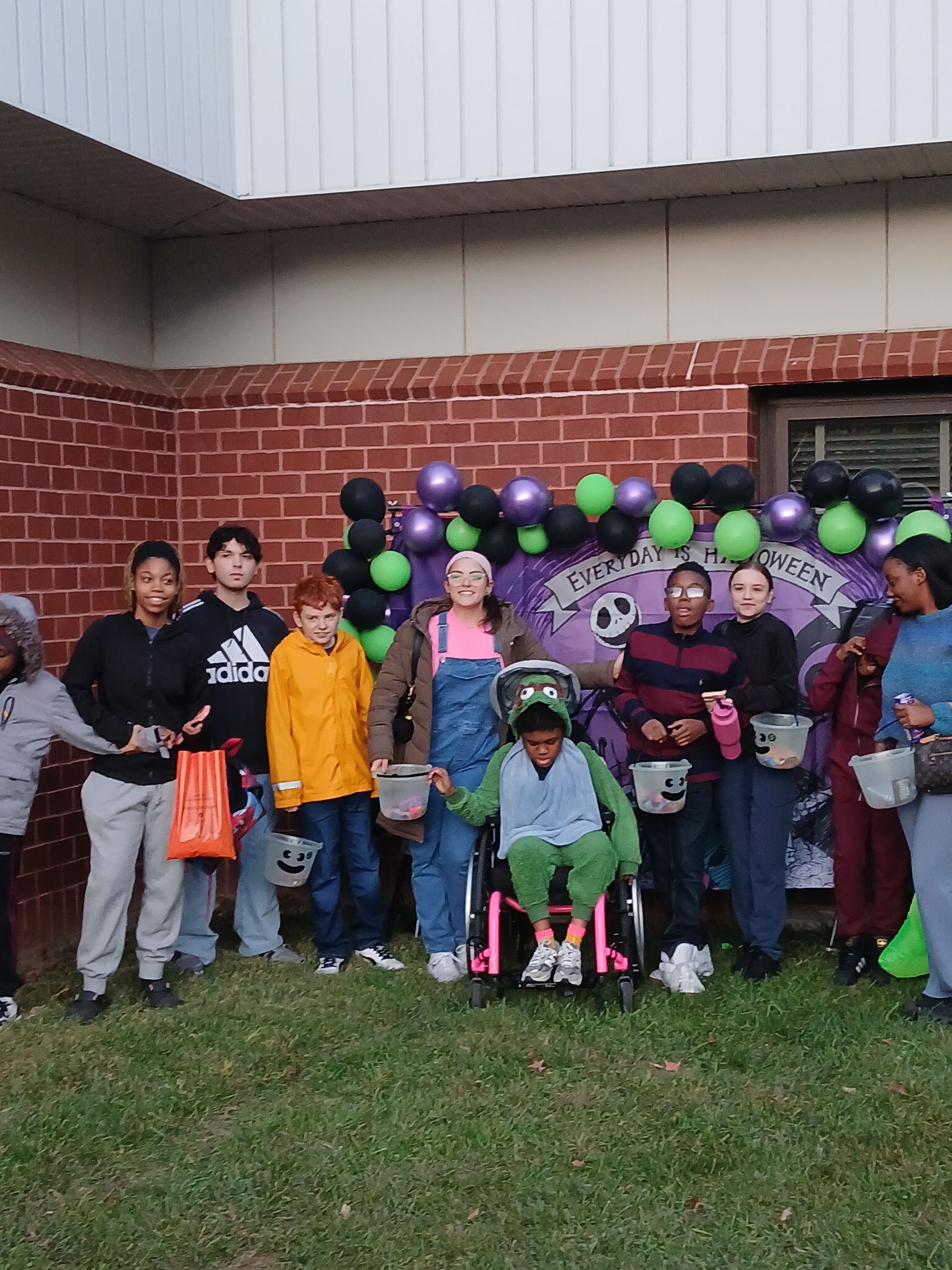 Two children smiling at a table with toys and papers. 