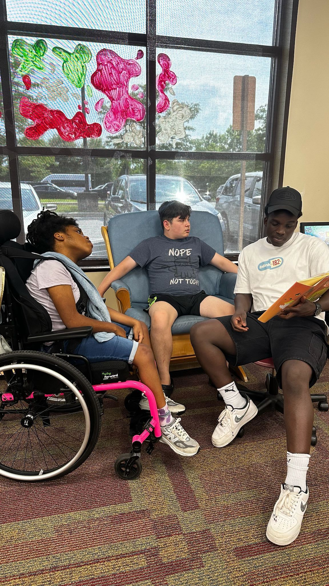 Three people reading in a library.