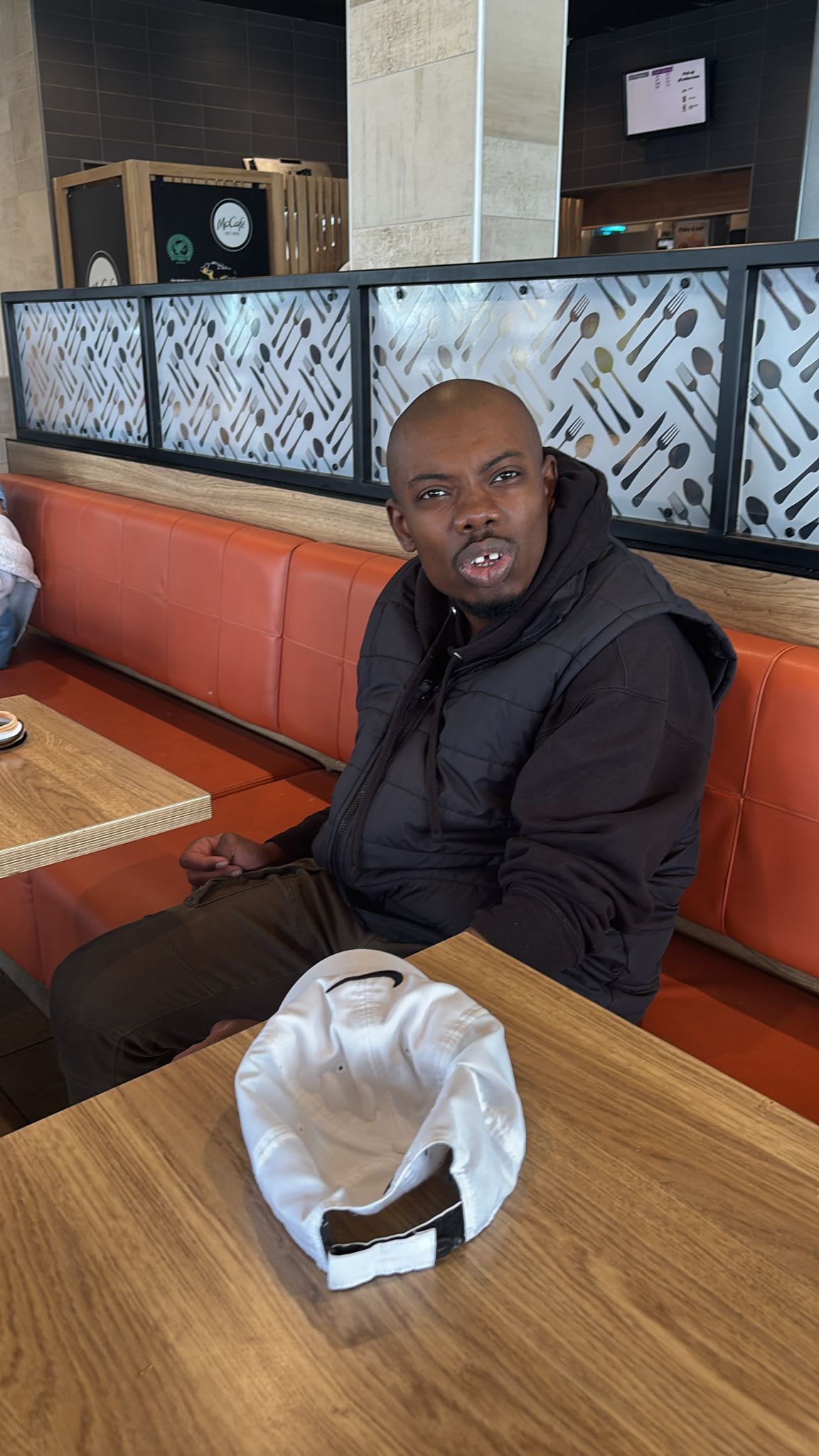 Man seated at a restaurant table, looking surprised. 