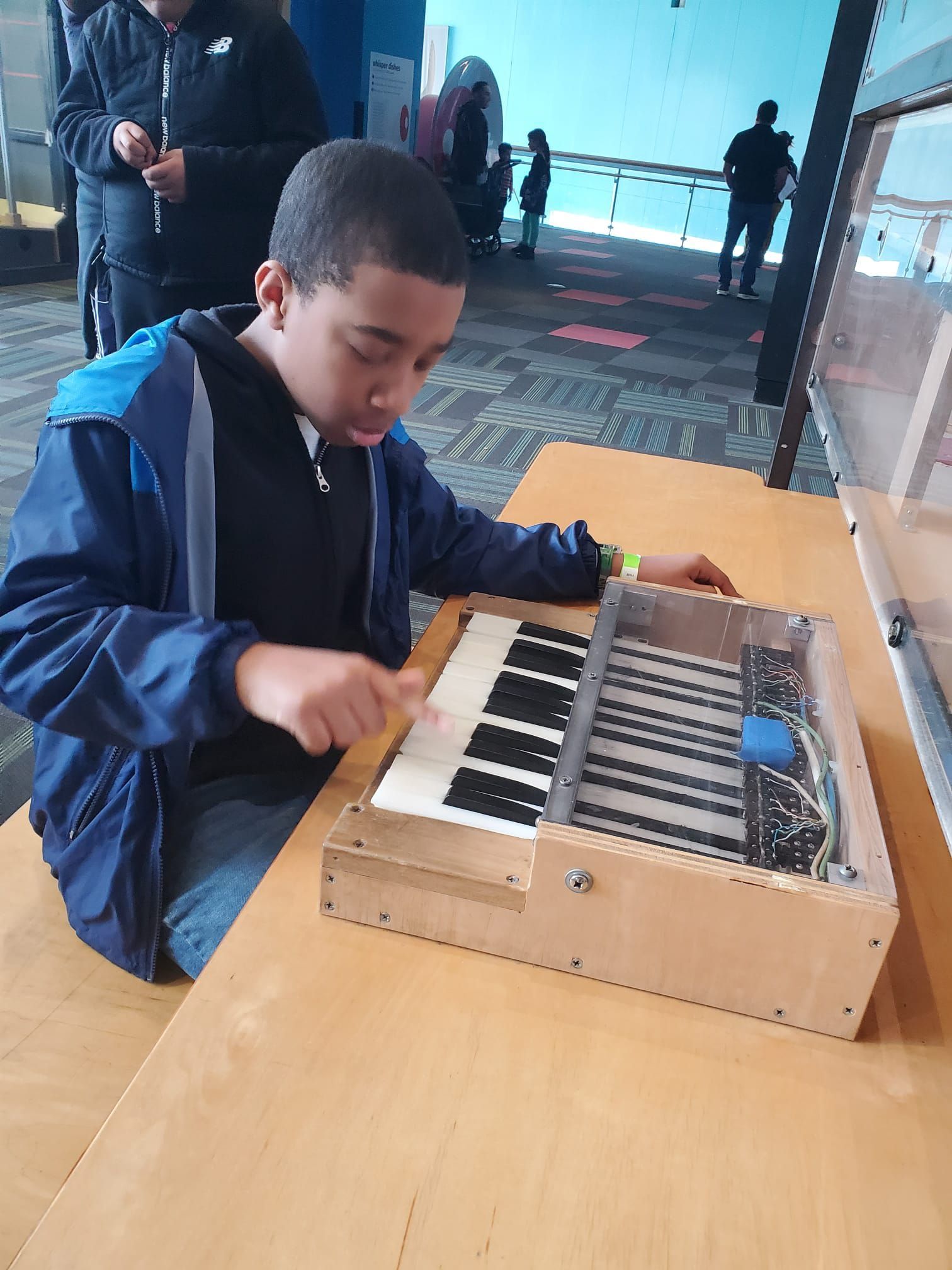Boy plays a musical instrument with keys in a museum.
