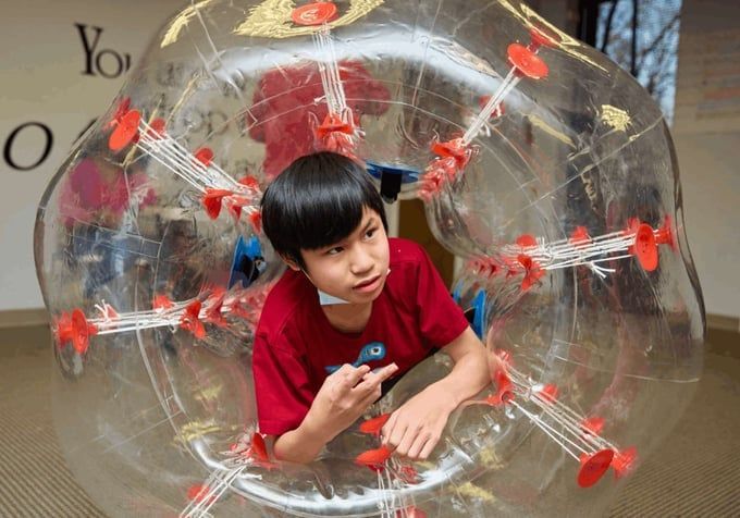 Boy in a transparent bubble suit, indoors. 
