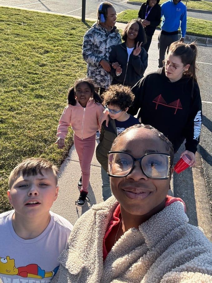 Group of people walking outside on a sunny day.
