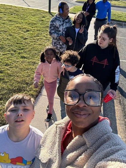 Group of people walking outside on a sunny day.