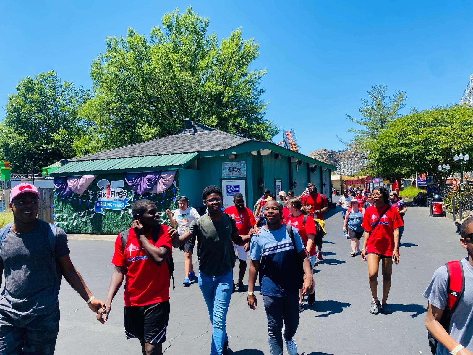 Group of people walking on a sunny day at an amusement park. 