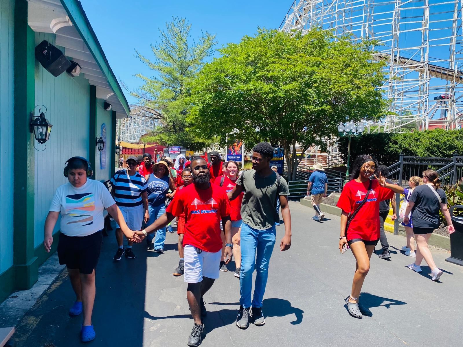 Group of people walking in amusement park;.