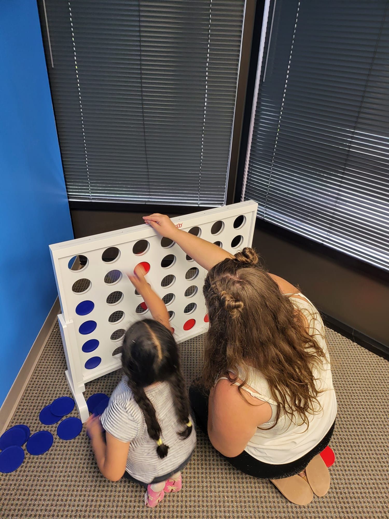 Woman and child playing giant Connect Four game. 