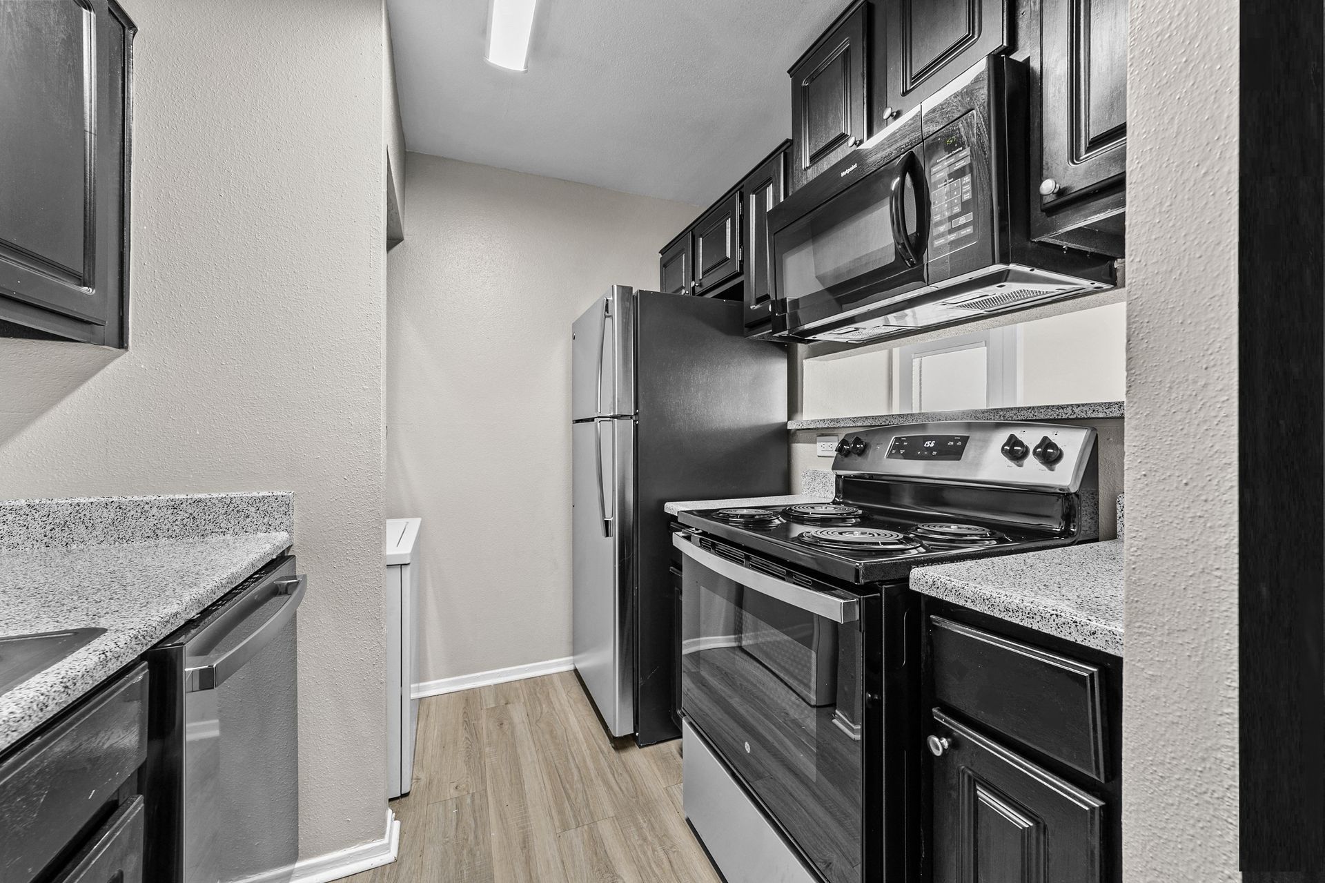 A well-equipped kitchen featuring black appliances and granite countertops.