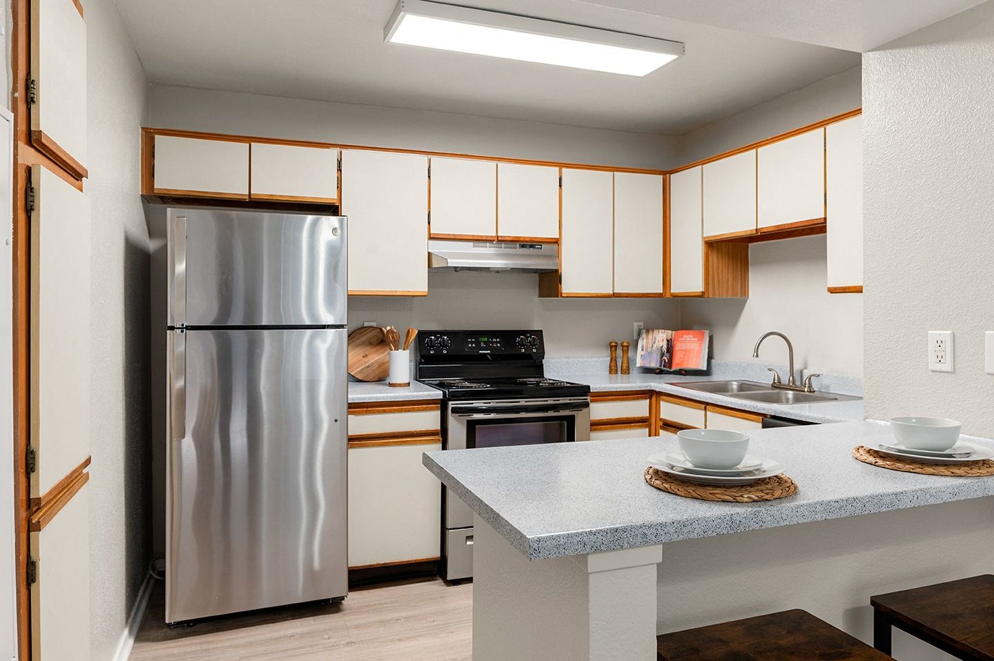 Modern kitchen with stainless steel appliances and dining setup.