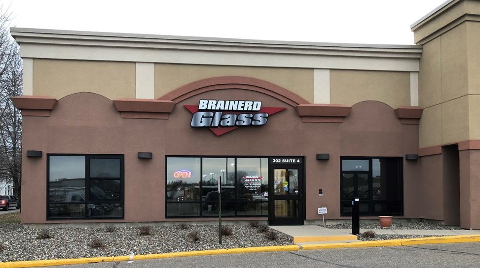 Brainerd Glass storefront with brown and tan facade; large windows; sign above entrance.