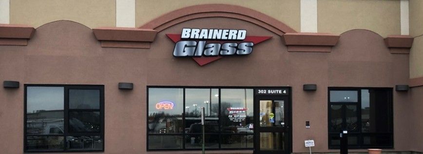 Building storefront with double doors and large windows. Beige brick and light gray.