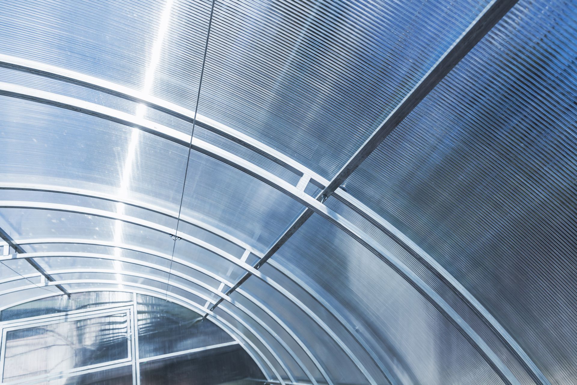 Curved translucent roof with white metal supports.