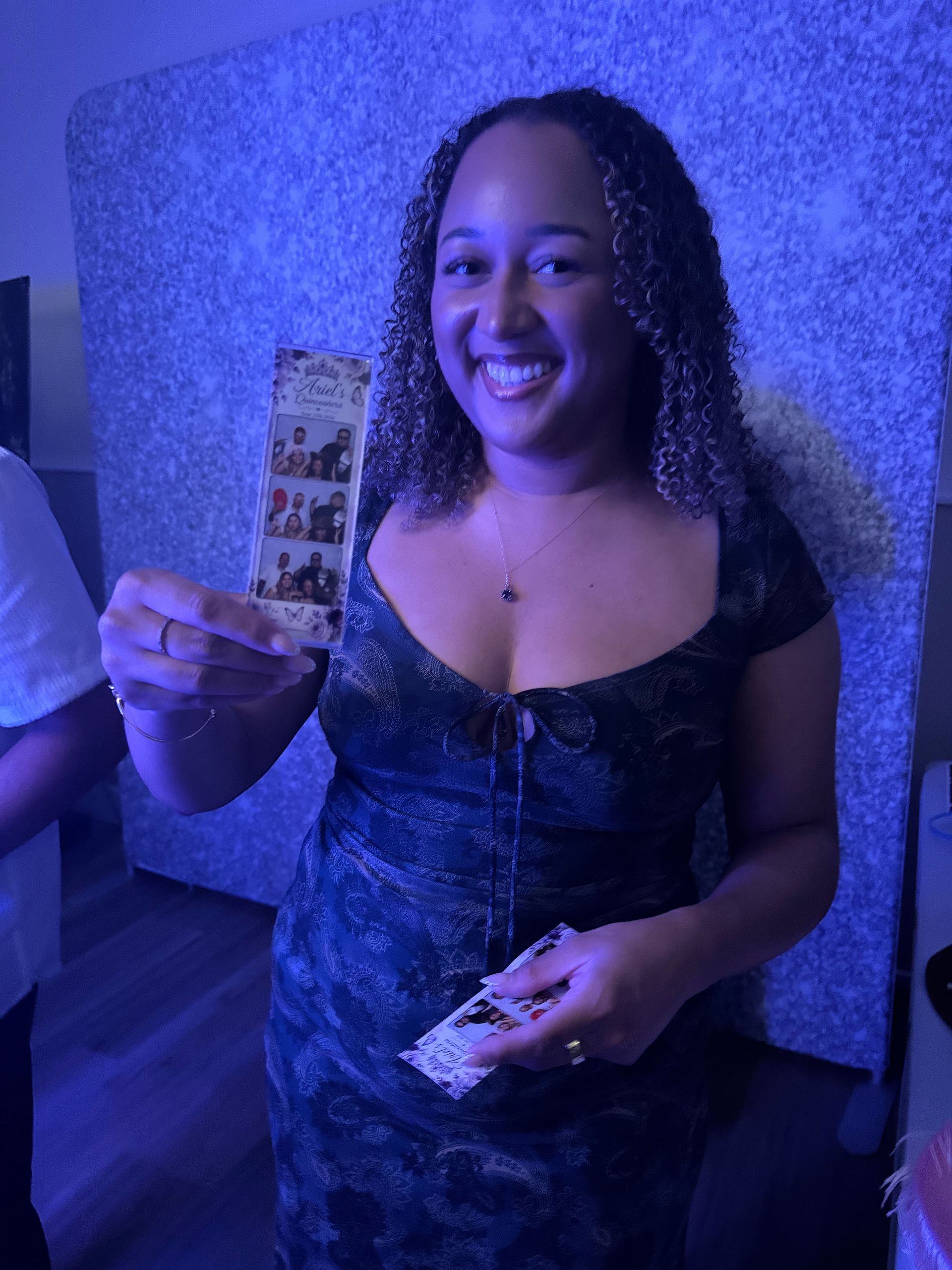 Guest holding a custom photo strip from the Brightlight Luxury Photo Booth in Hemet, CA