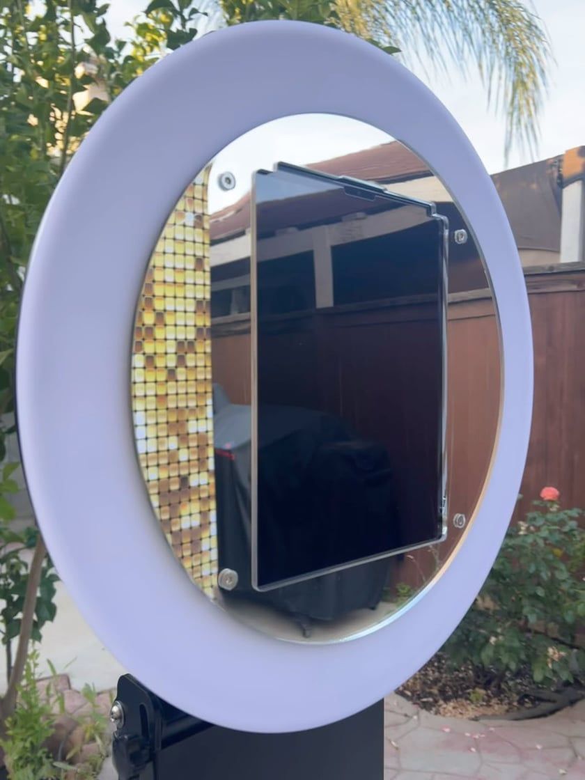 A woman in a hat is standing in front of red roses.