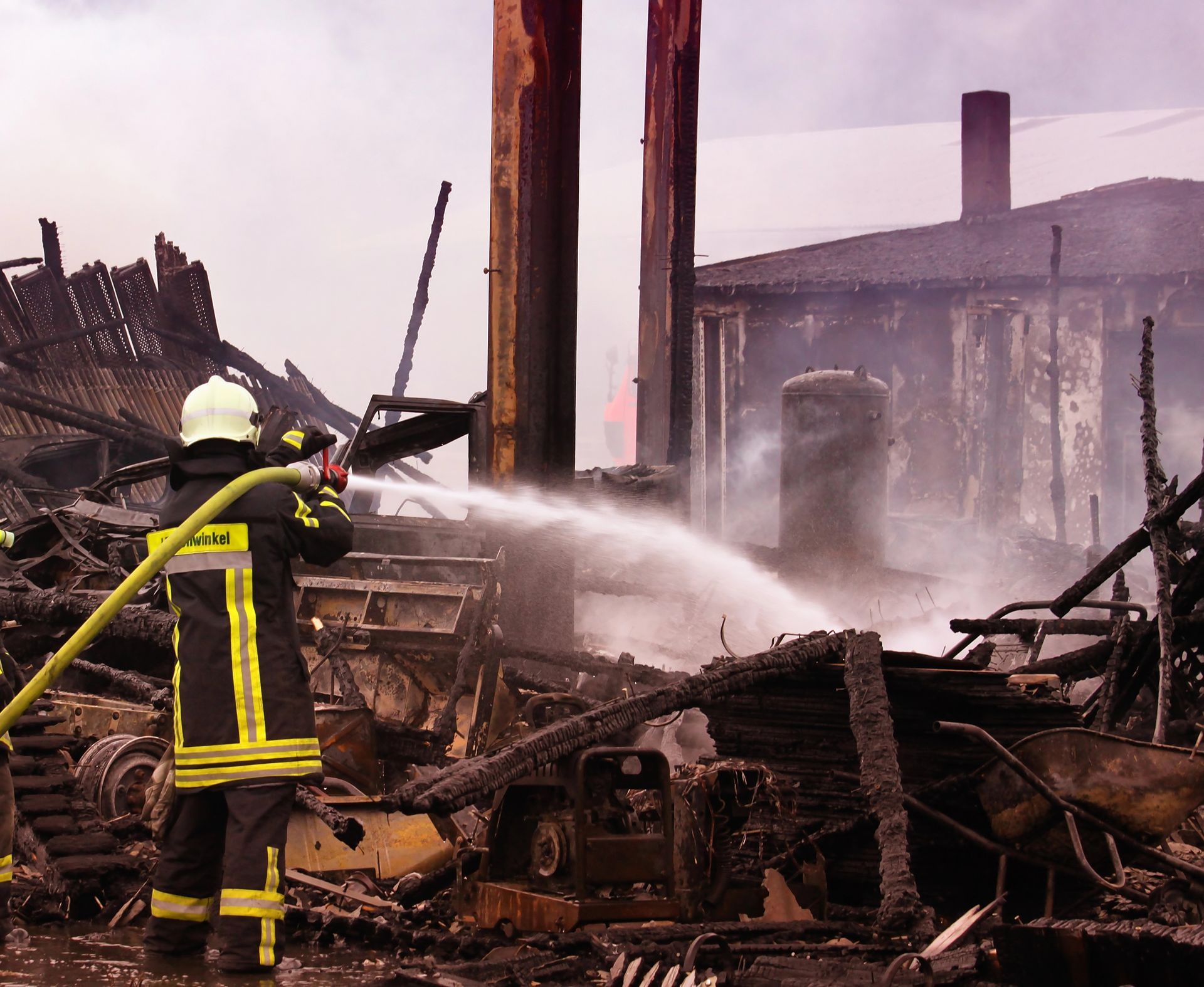 A Fire Fighter working on extinguishing a home under fire 