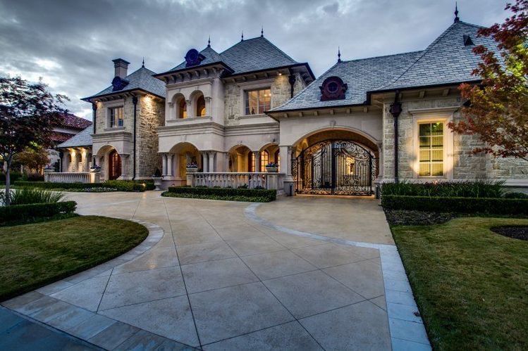 A very large house with a large driveway in front of it.