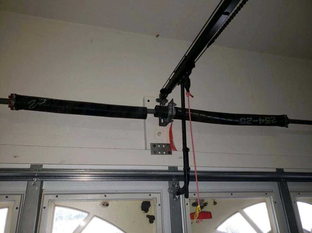 Garage door springs mounted above the garage door. Two black springs are visible.